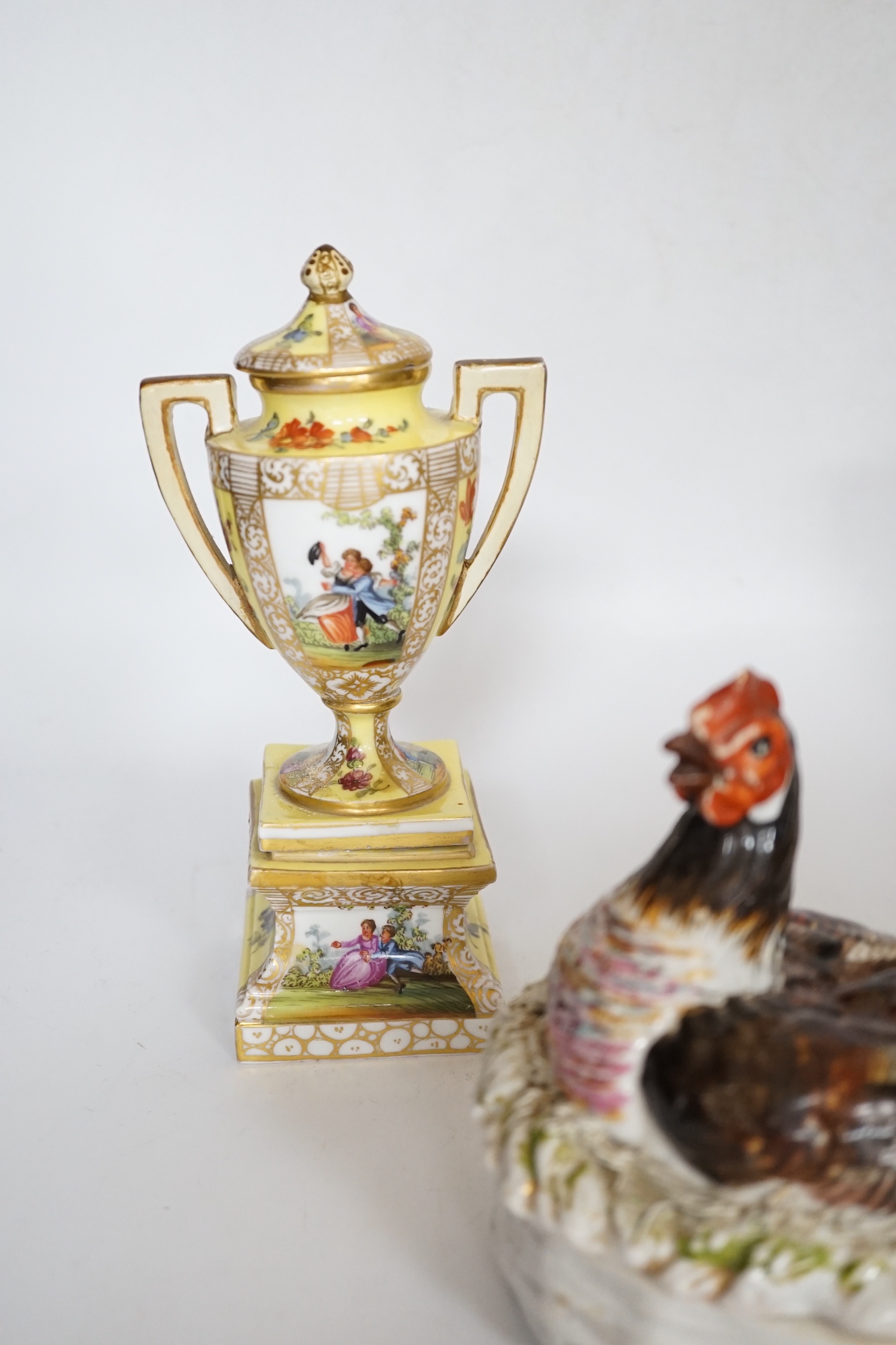 A pair of Dresden porcelain vases and covers (restored) together with a hen egg basket and cover, largest 19cm high (3)